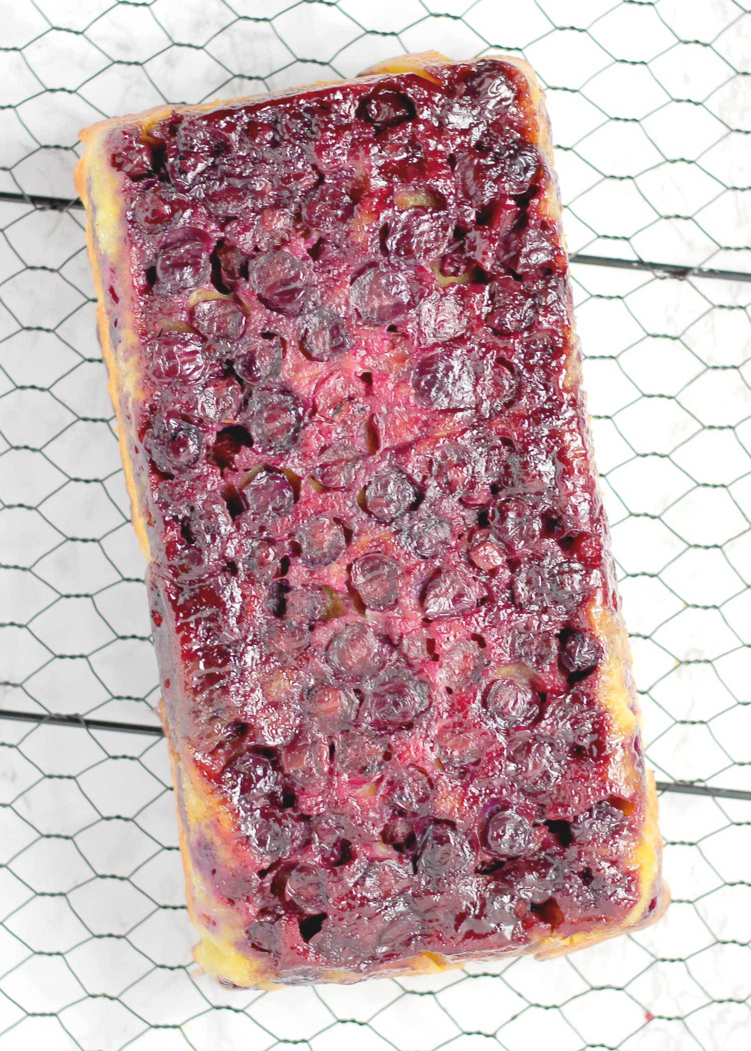 a cooling rack with a loaf of blueberry upside down bread
