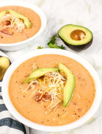 bowl of Mexican Chicken soup with avocado in the background