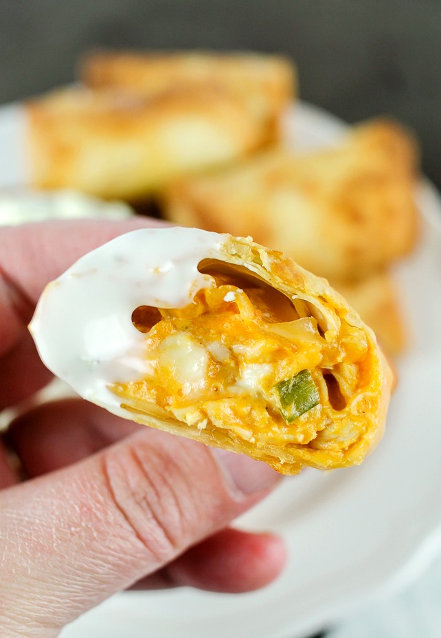 a bite of buffalo chicken egg roll dipped in blue cheese dressing