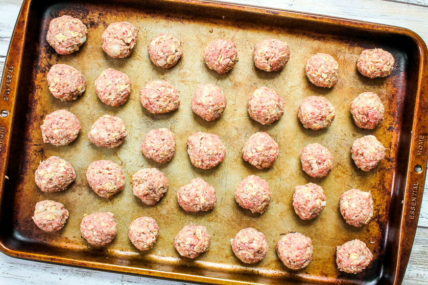 cookie sheet with uncooked meatballs