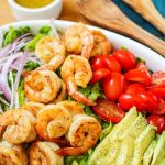 shrimp avocado salad with honey lime dressing, avocados, red onions and tomatoes