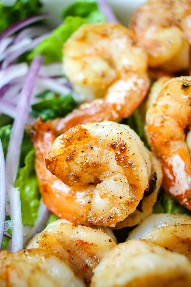 honey lime grilled marinated shrimp on top of a salad