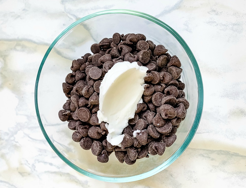 a glass bowl with chocolate chips and shortening