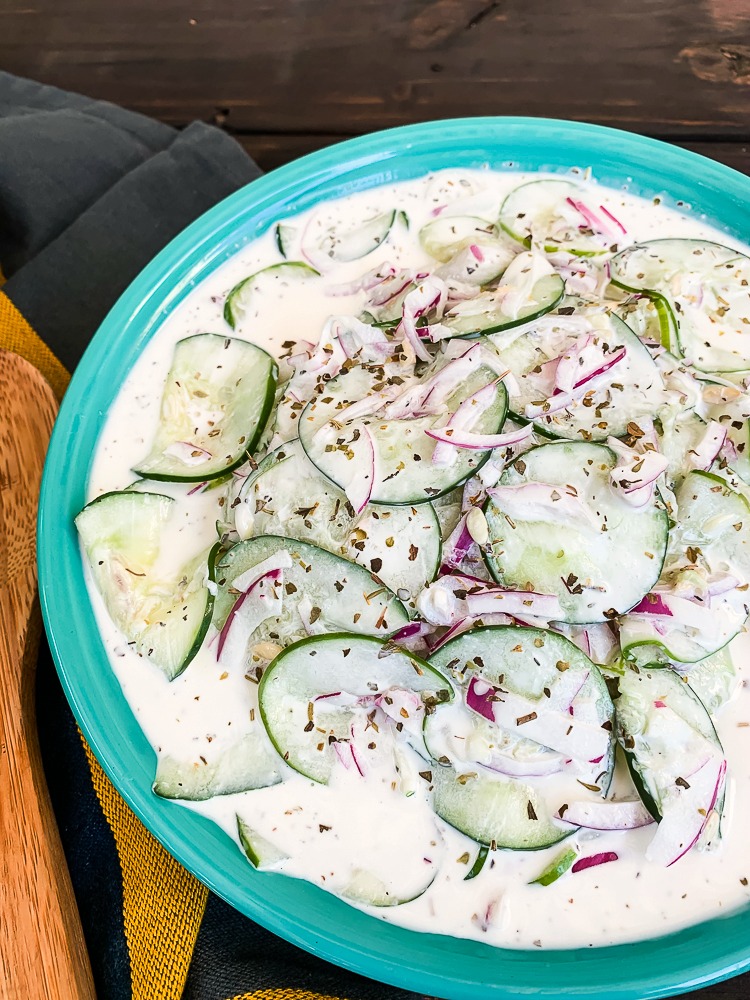 blue bowl with cucumber salad made with mayo and sour cream