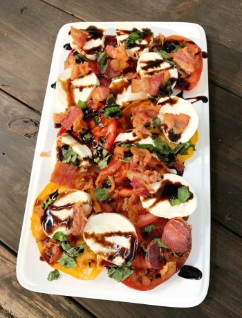 white rectangle tray with caprese salad with bacon and a balsamic drizzle