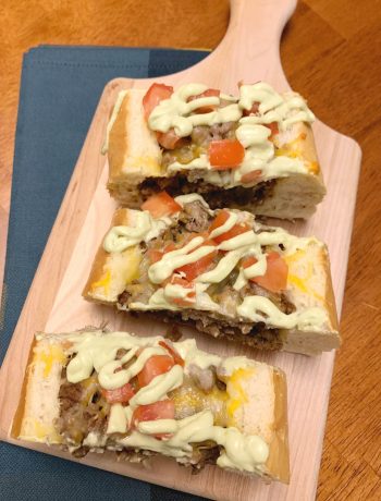 3 slices of Cheeseburger French Bread on a cutting board