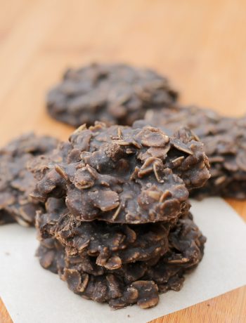 a stack of dark chocolate no bake oatmeal cookies on a square of parchment paper