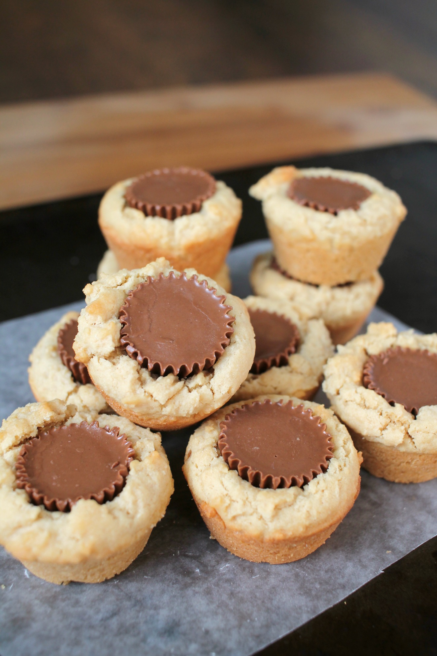 a pile of peanut butter cup cookies that look like mini peanut butter muffins with a Reese's in the middle