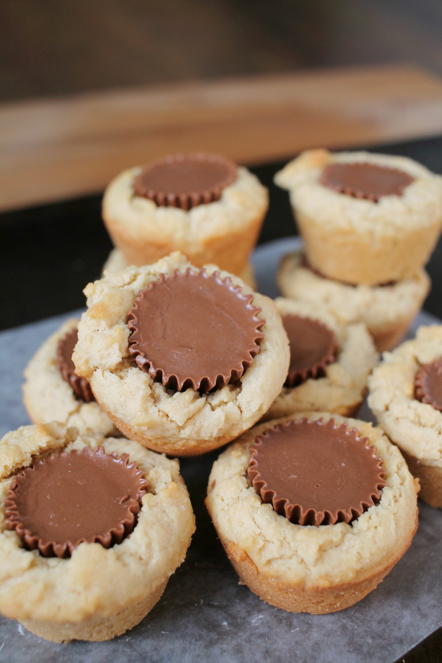 a pile of peanut butter cup cookies that look like mini peanut butter muffins with a Reese's in the middle