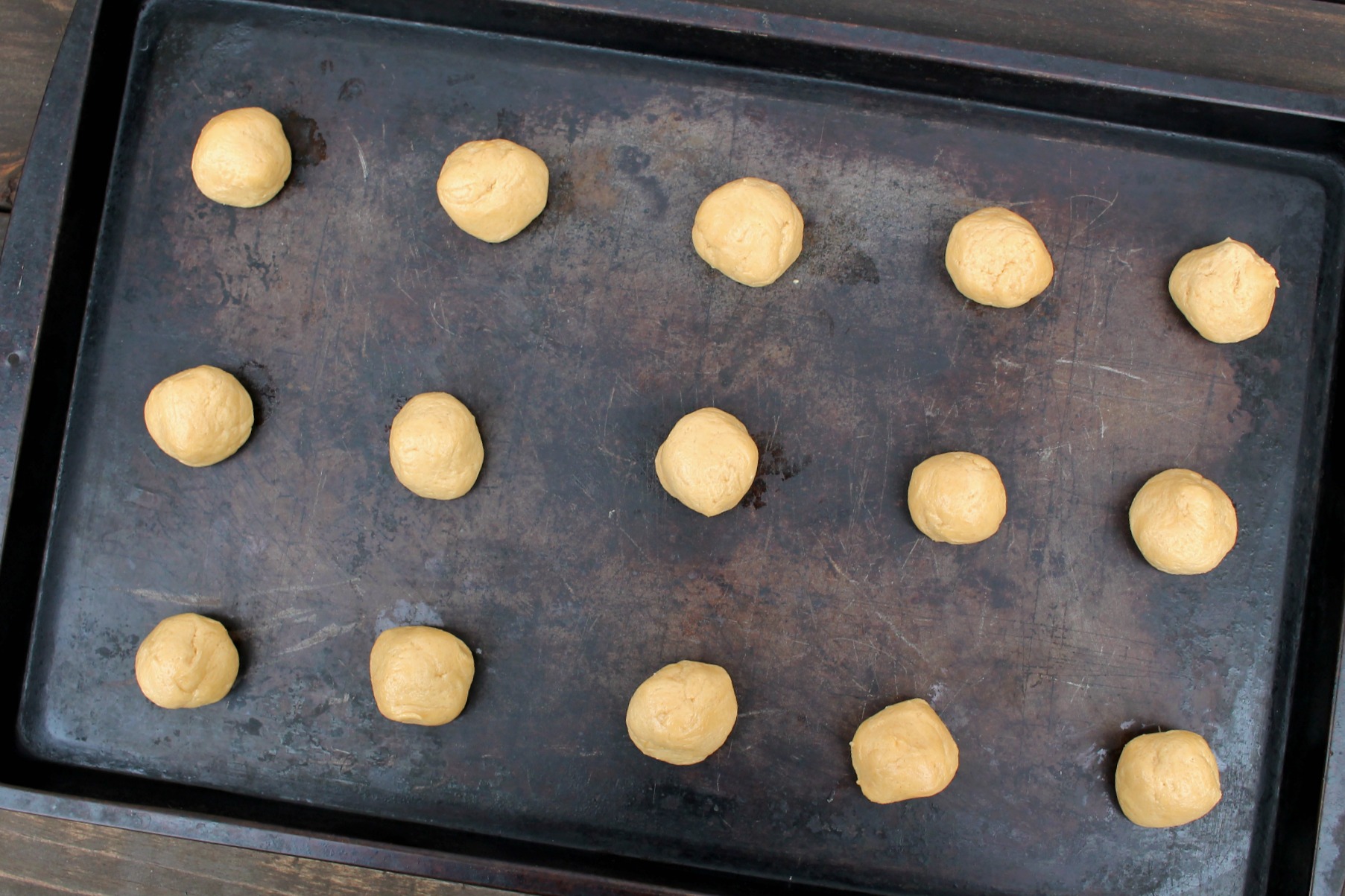 cookie sheet with balls of peanut butter cookie dough