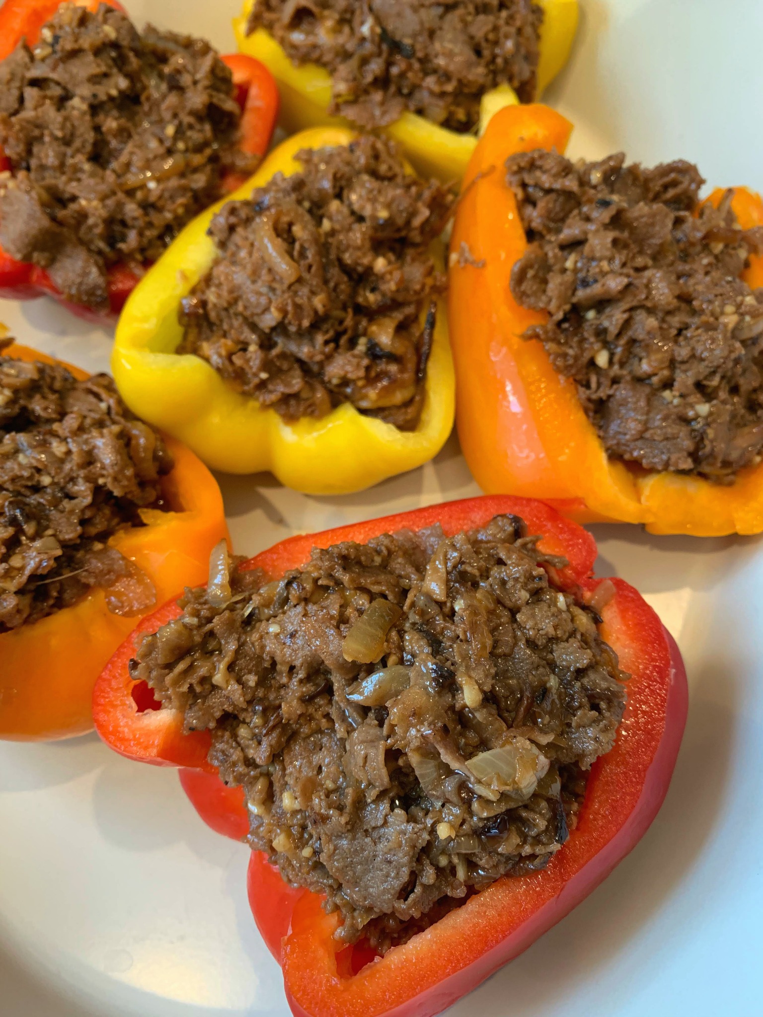 red, yellow and orange pepper halves filled with cheesesteak mixture