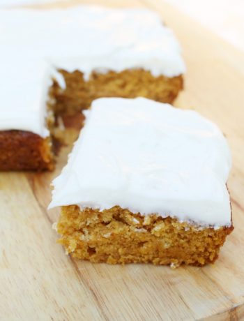 a slab of Pumpkin Cake with Cream Cheese Frosting with the corner piece cut out and pushed to the front of the picture