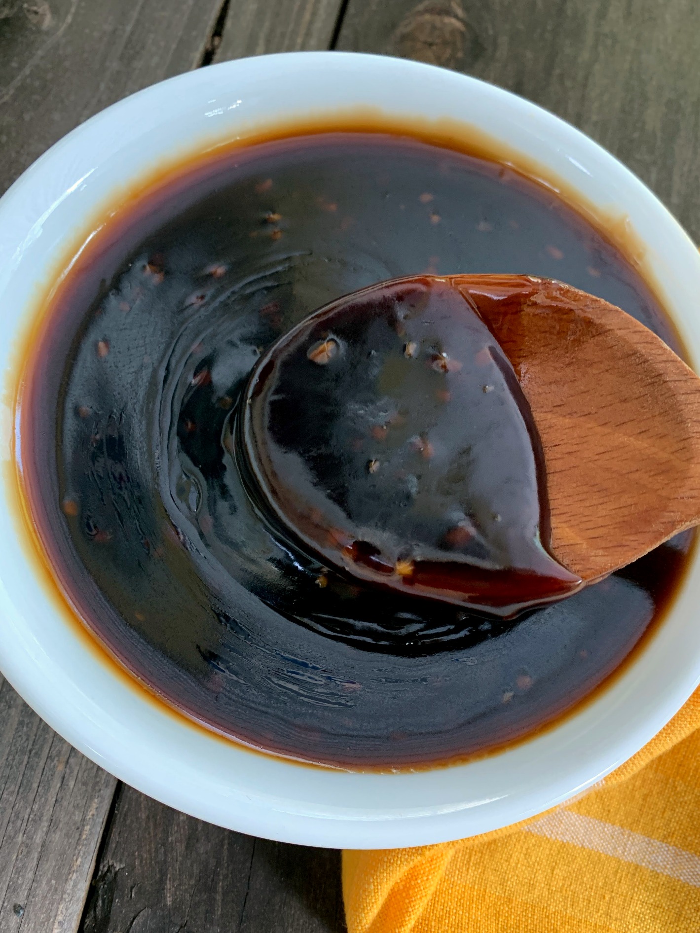 Teriyaki Glaze and Marinade in a white bowl with a wooden spoon
