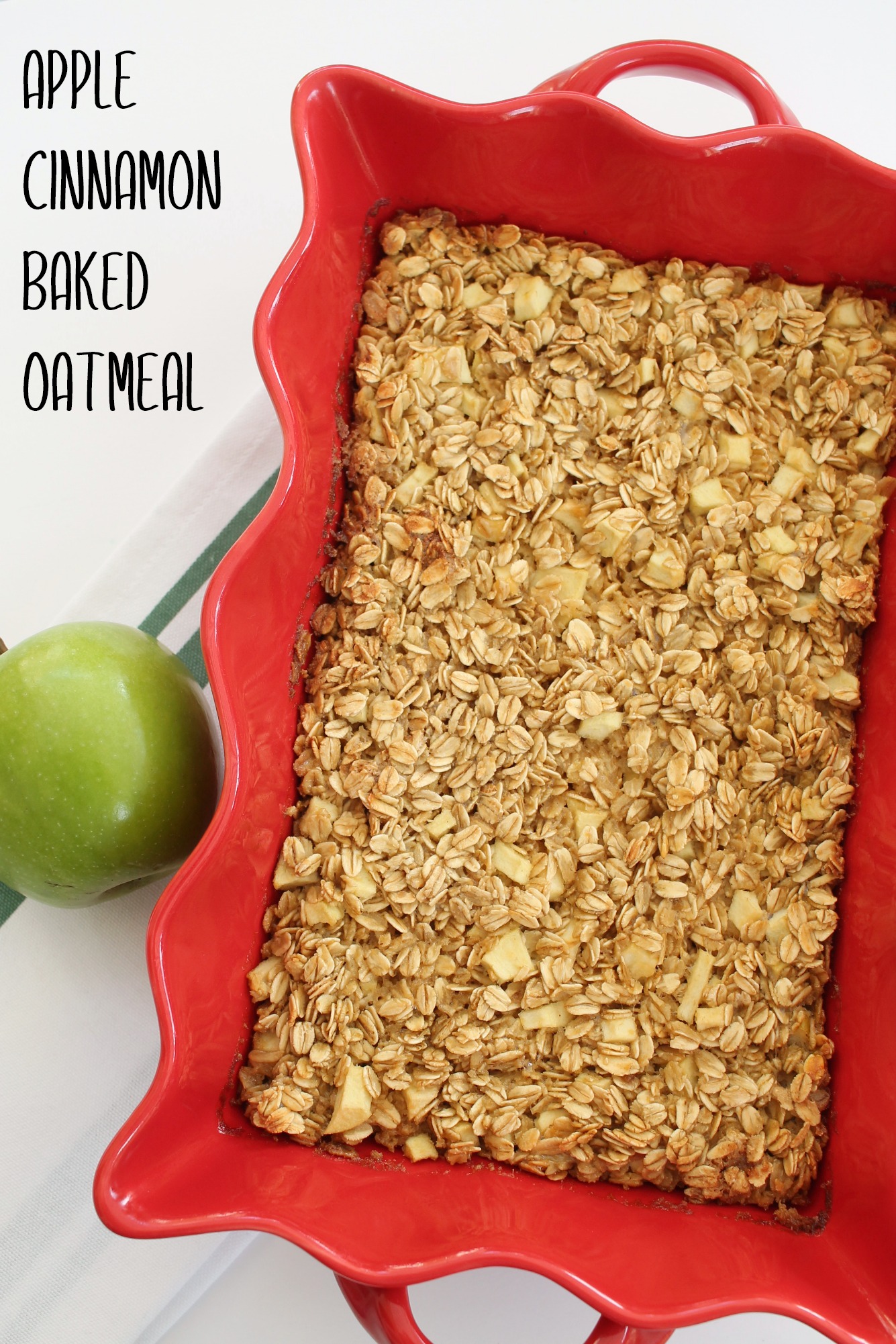 a red rectangle dish filled with apple cinnamon baked oatmeal with a green apple sitting beside it