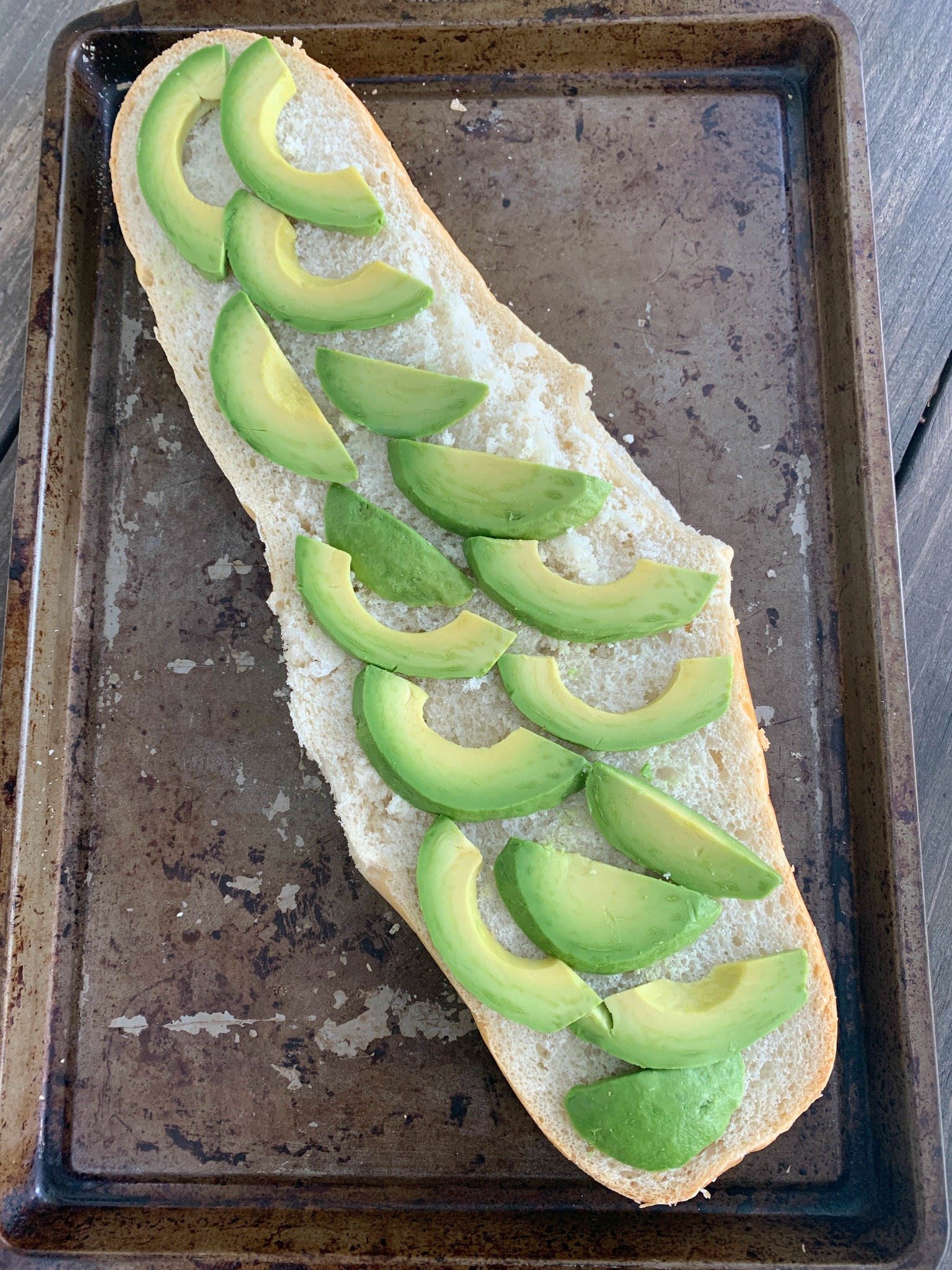 half a loaf of french bread with avocado slices
