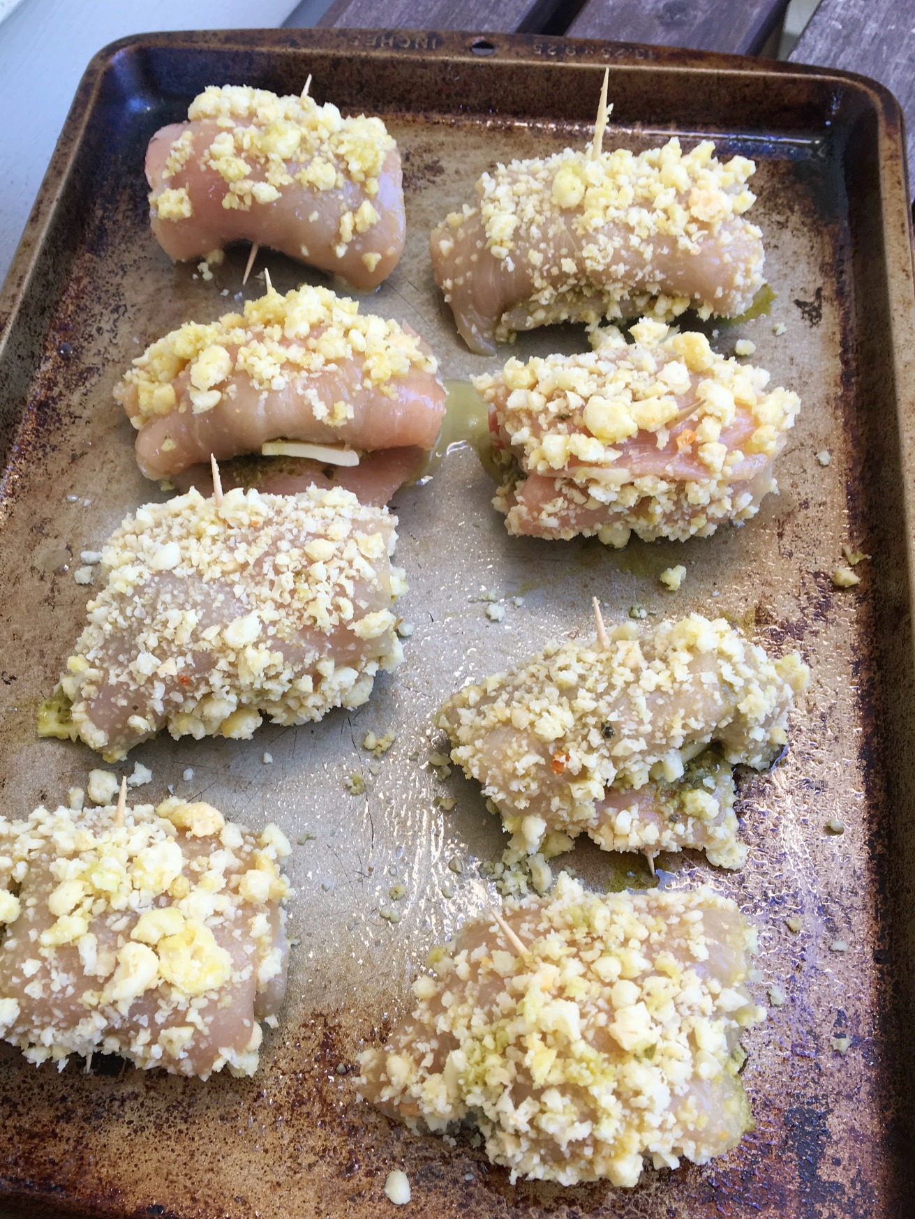 pesto chicken roll-ups uncooked on a baking sheet