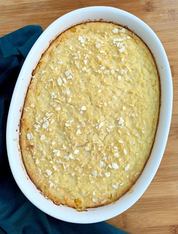 a white oval dish with baked scalloped corn