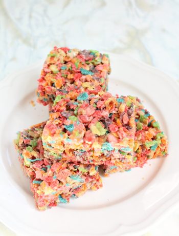round white plate with 4 squares of Fruity Pebbles Rice Krispies stacked on top of each other