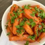 white bowl with cooked carrots and fresh parsley