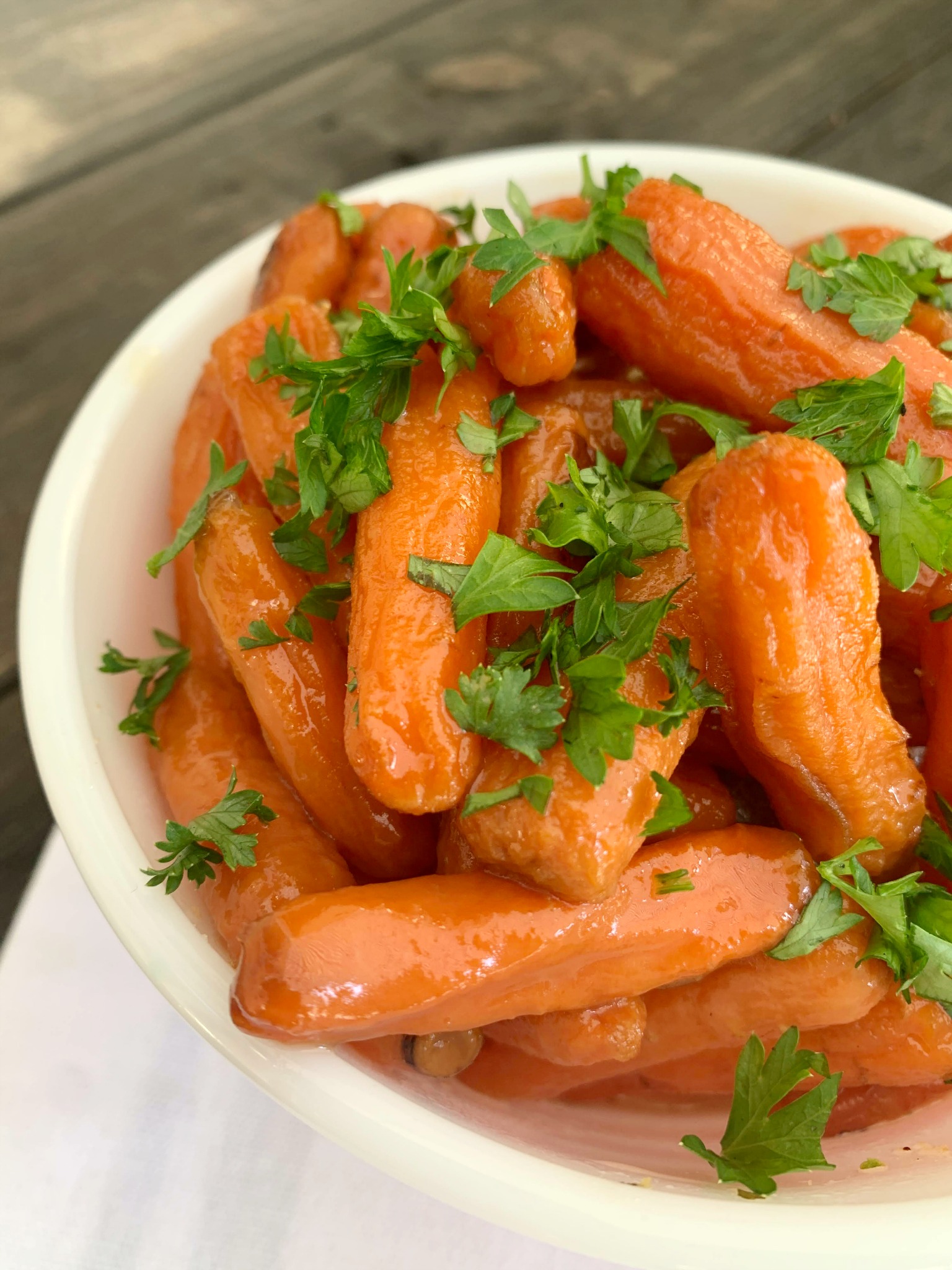 white bowl with cooked carrots and fresh parsley