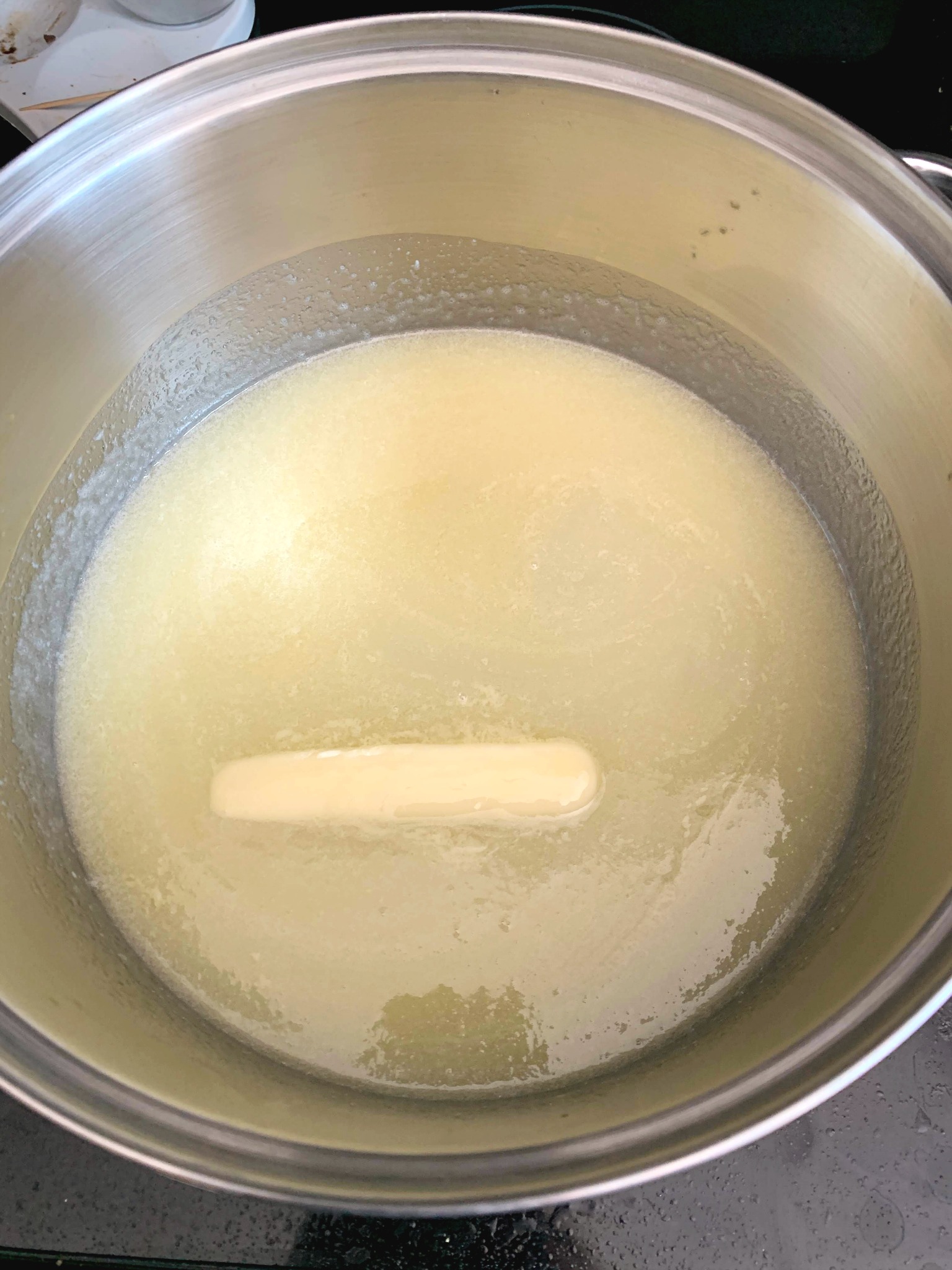 saucepan with milk, sugar and a stick of butter