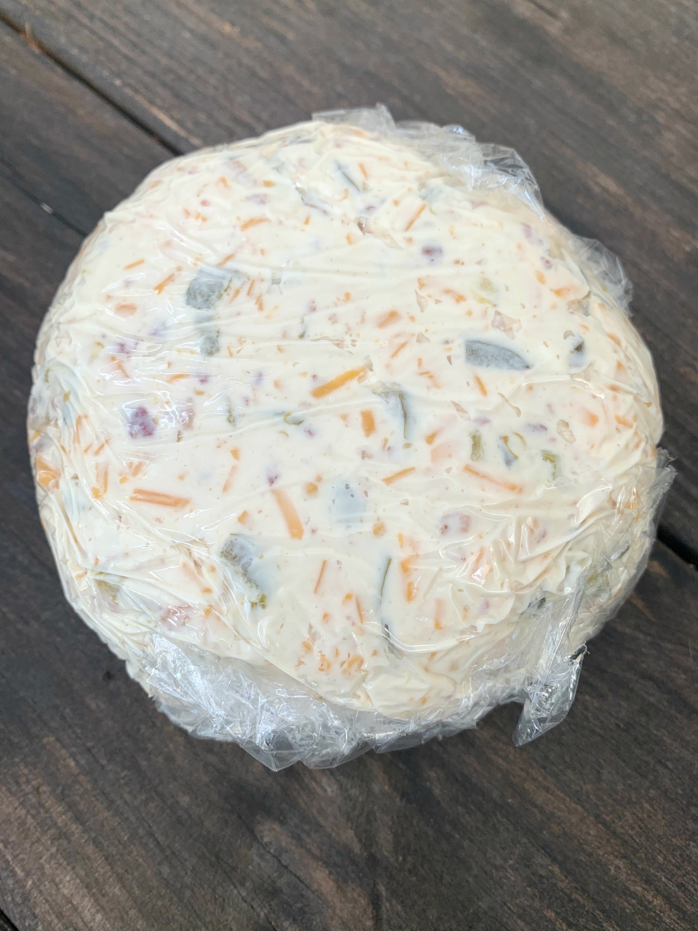 a cheeseball wrapped in plastic wrap