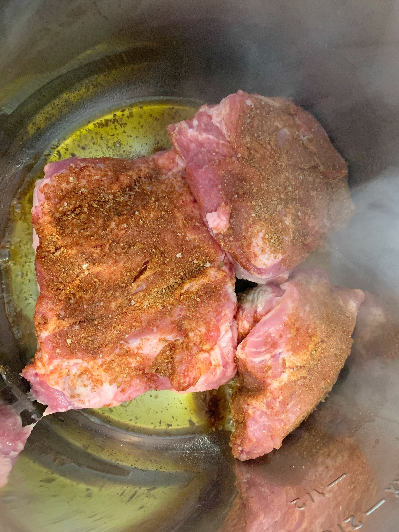 3 pieces of seasoned pork being put in the instant pot