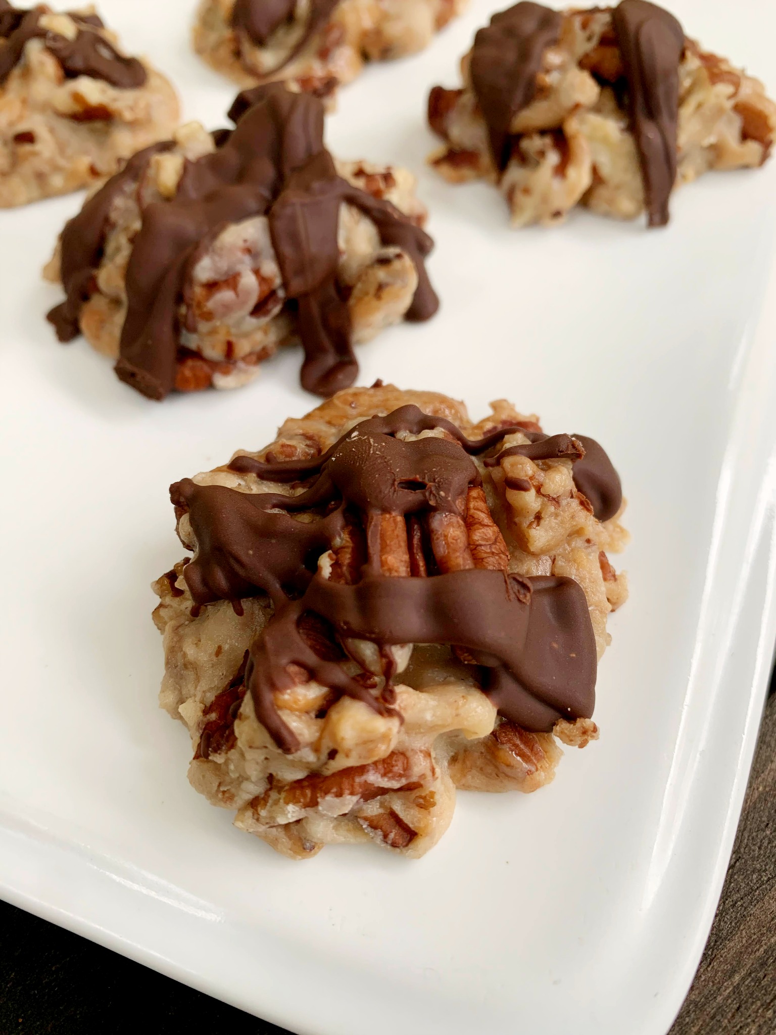 pecan pralines with chocolate drizle on a white tray