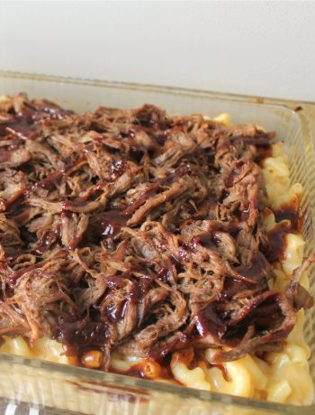 mac and cheese topped with pulled pork and drizzled with BBQ sauce