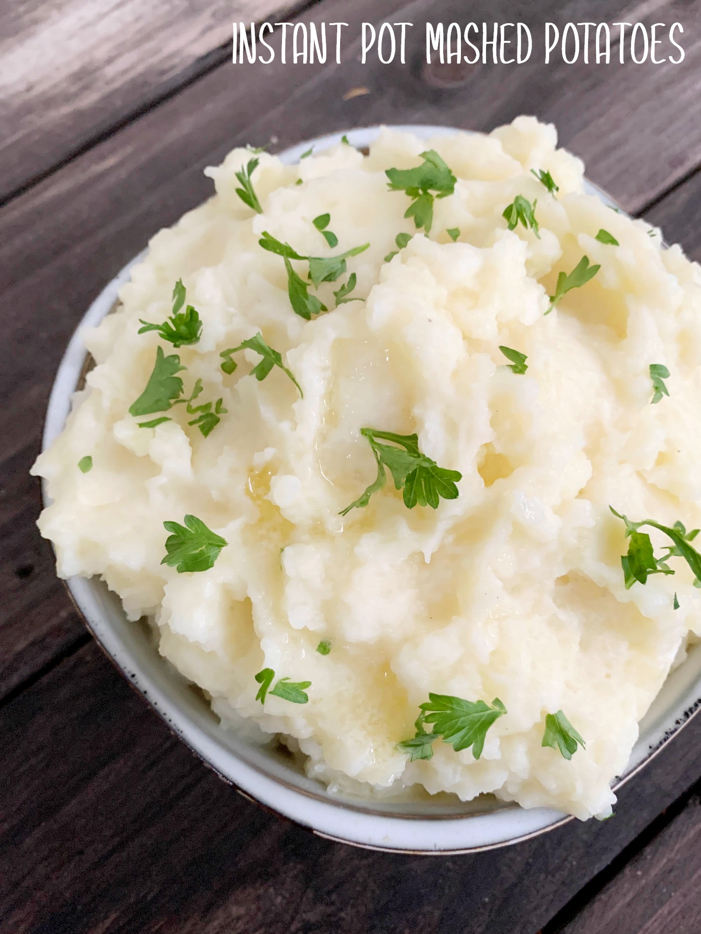 mashed potatoes in a bowl with melted butter and chopped parsley on top