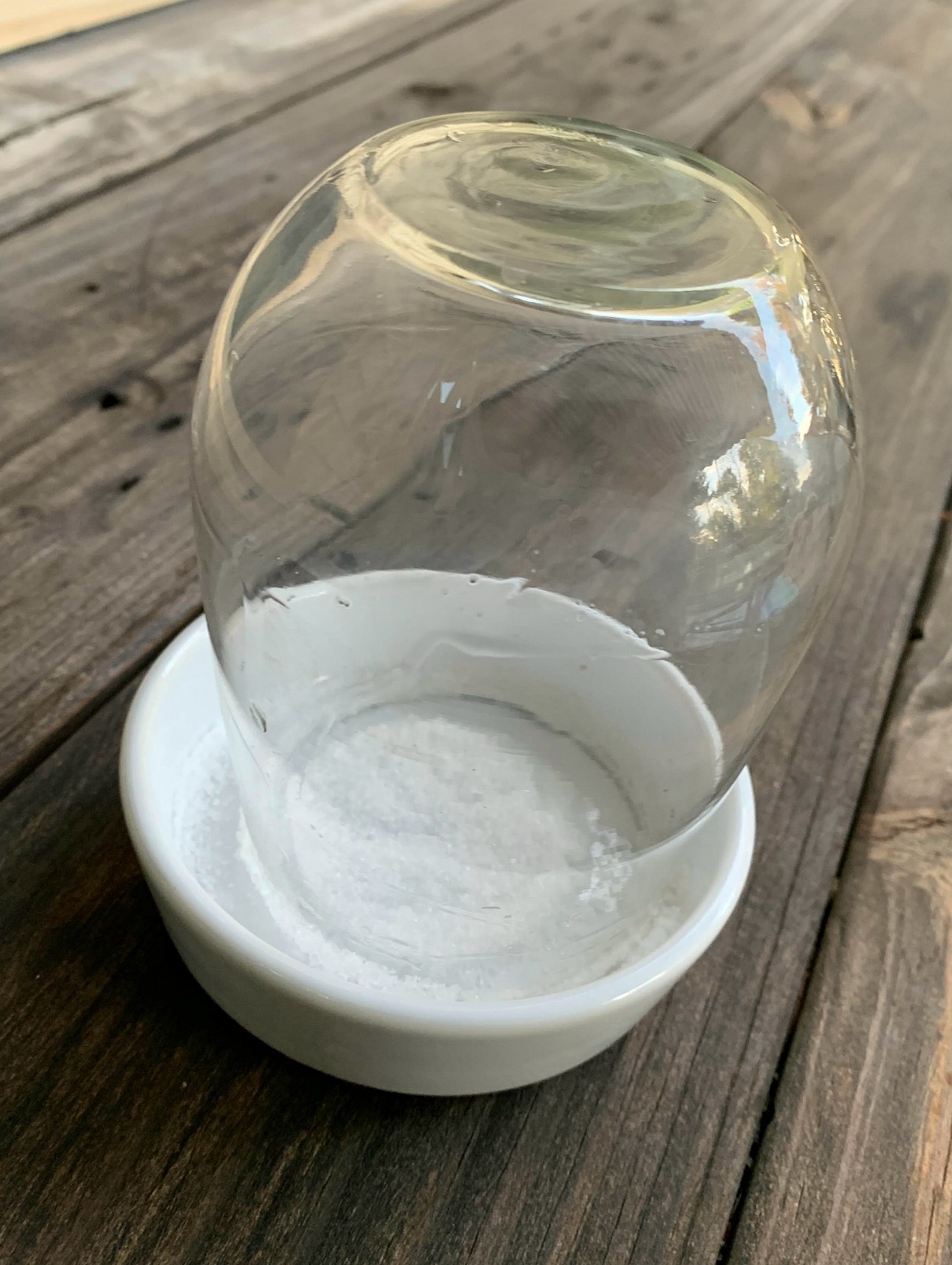 a glass upside down in a dish of sugar