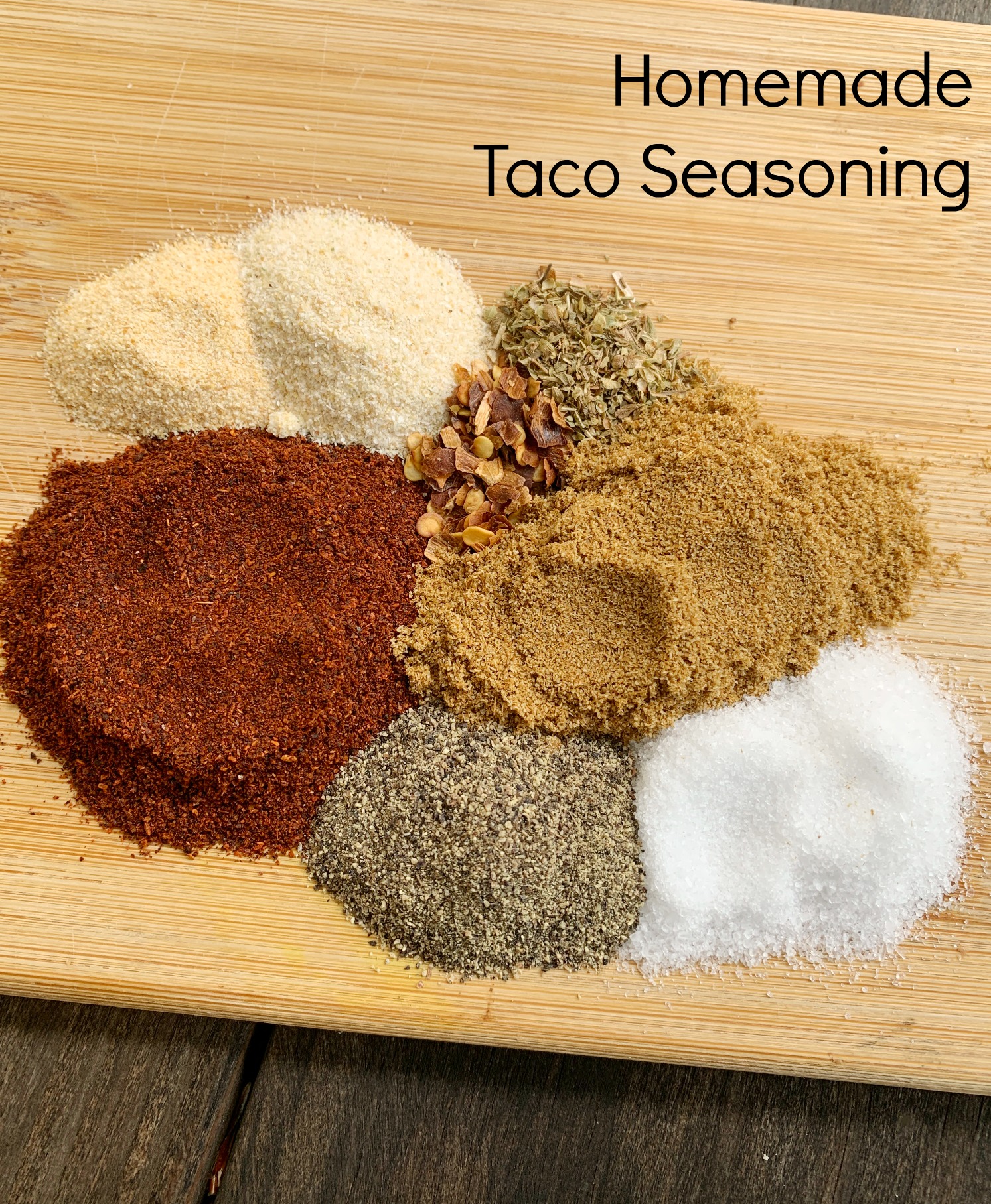spices separated in piles on a wooden cutting board