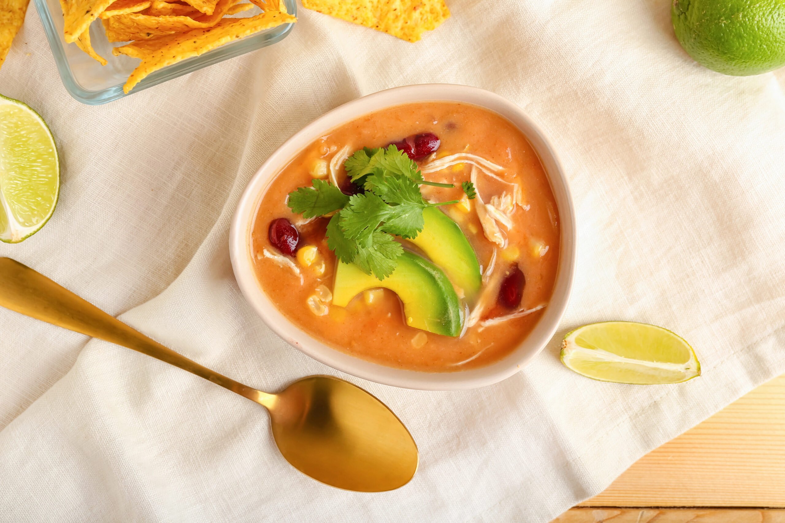 Bowl of tasty enchilada soup on table